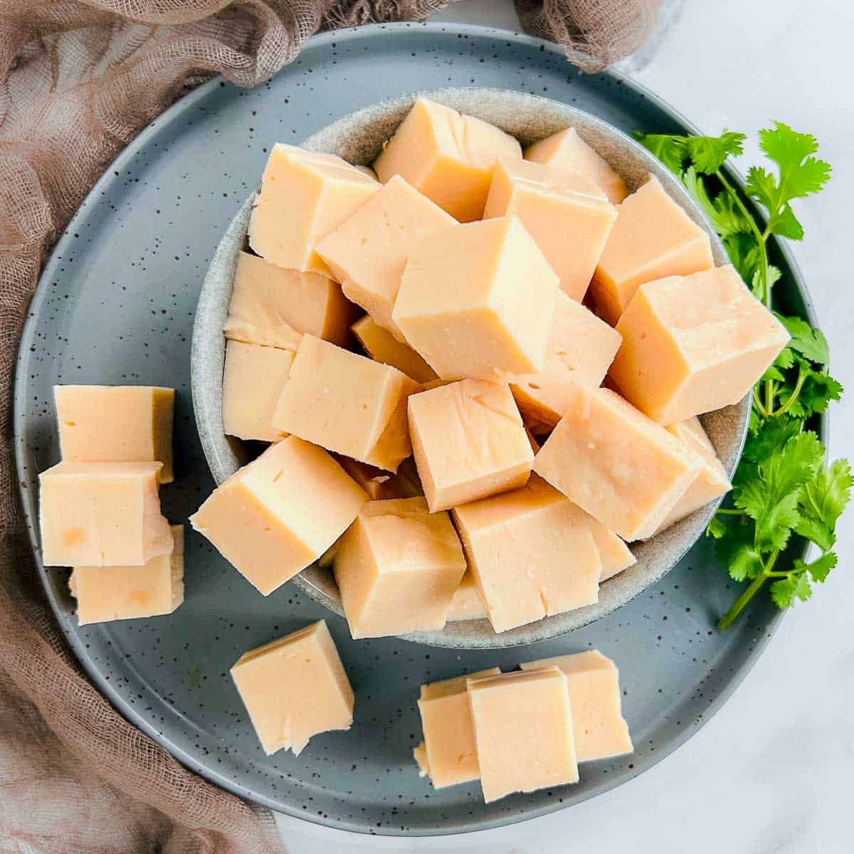 Red lentil tofu in a bowl with cilantro in the background.