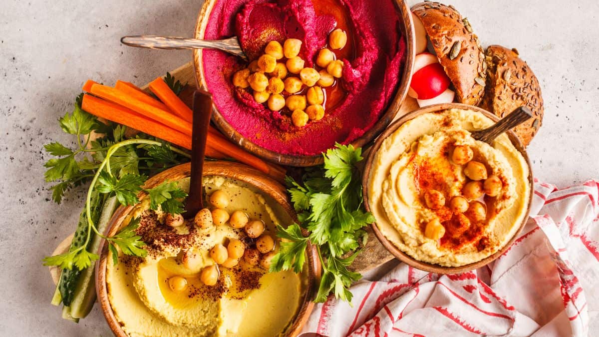 Different types of hummus served with dippers.