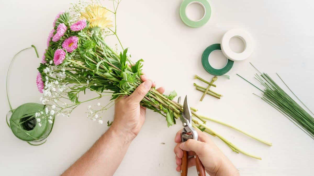 Person trimming the stems of flower.