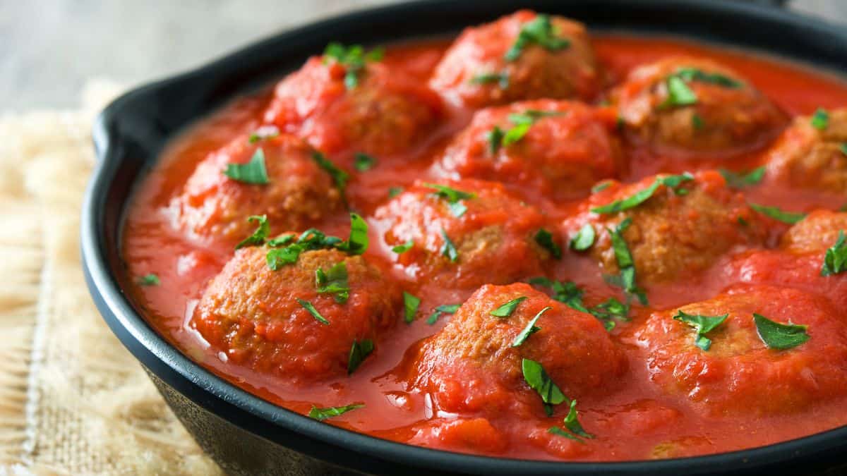 Meatballs and sauce in a skillet.