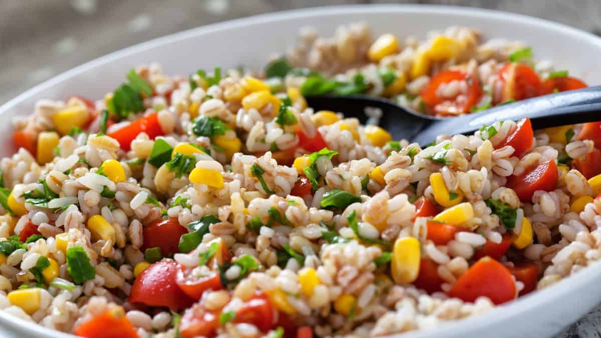 Rice and veggie salad on a white plate.