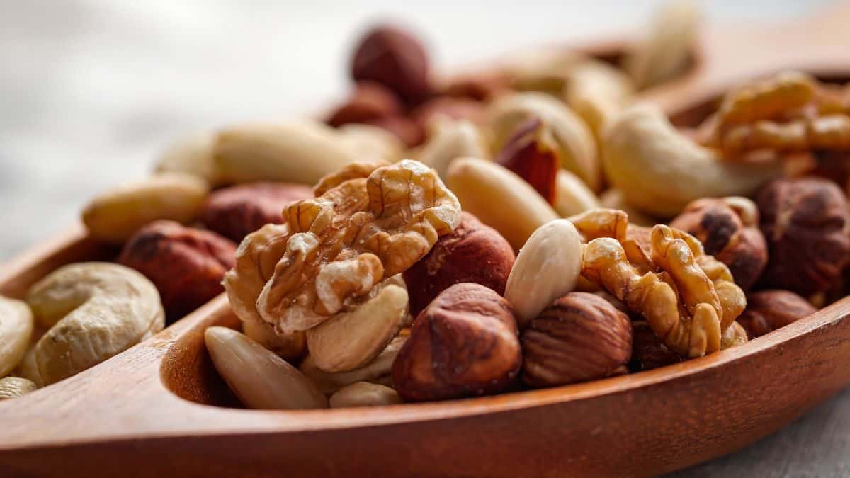 Mixed nuts on a wooden spoon.