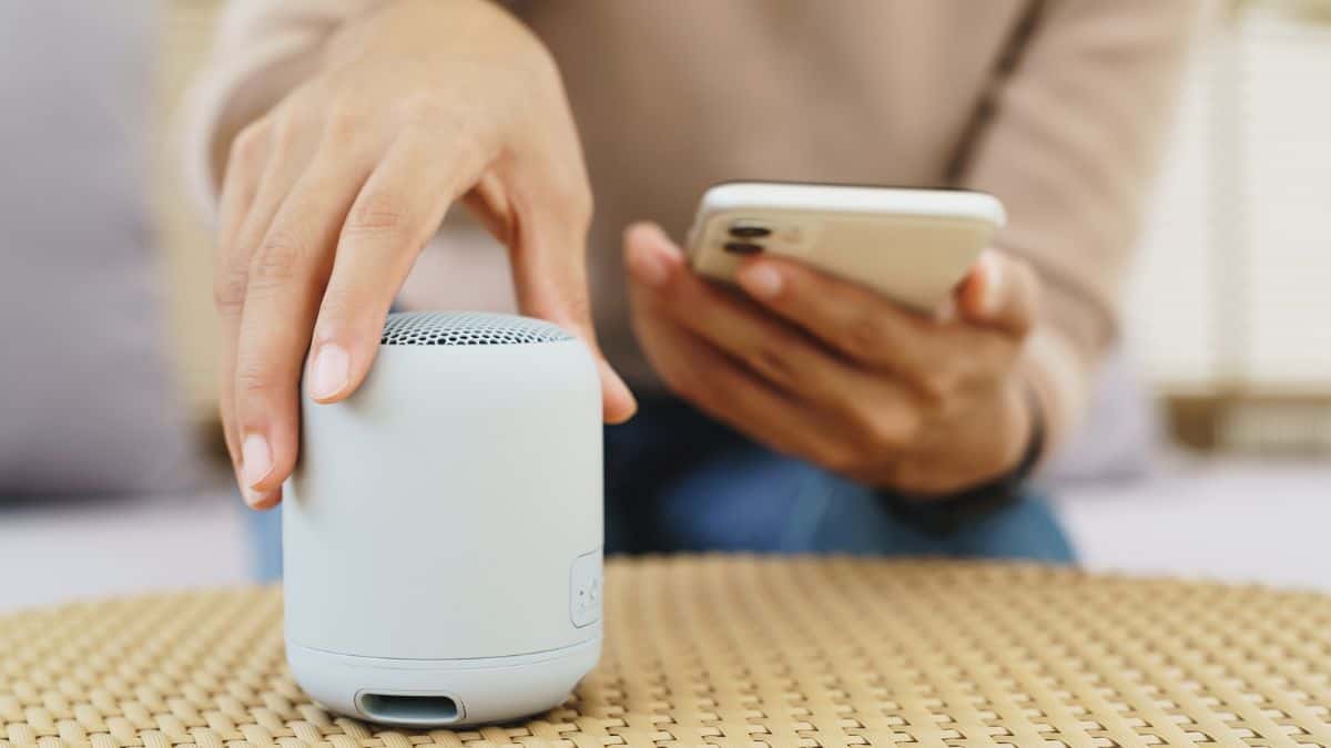 Woman playing portable speaker.