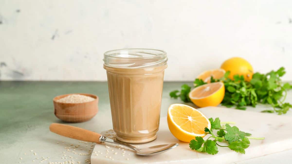 Tahini with orange and cilantro in the background.