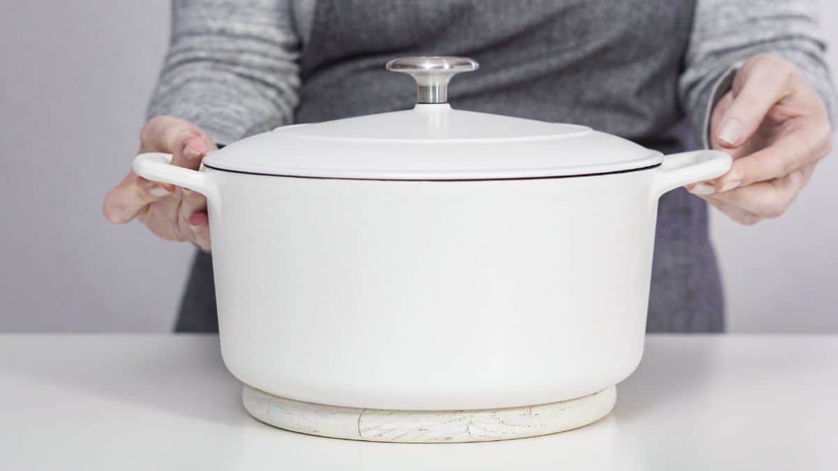 Man holding a white Dutch oven.