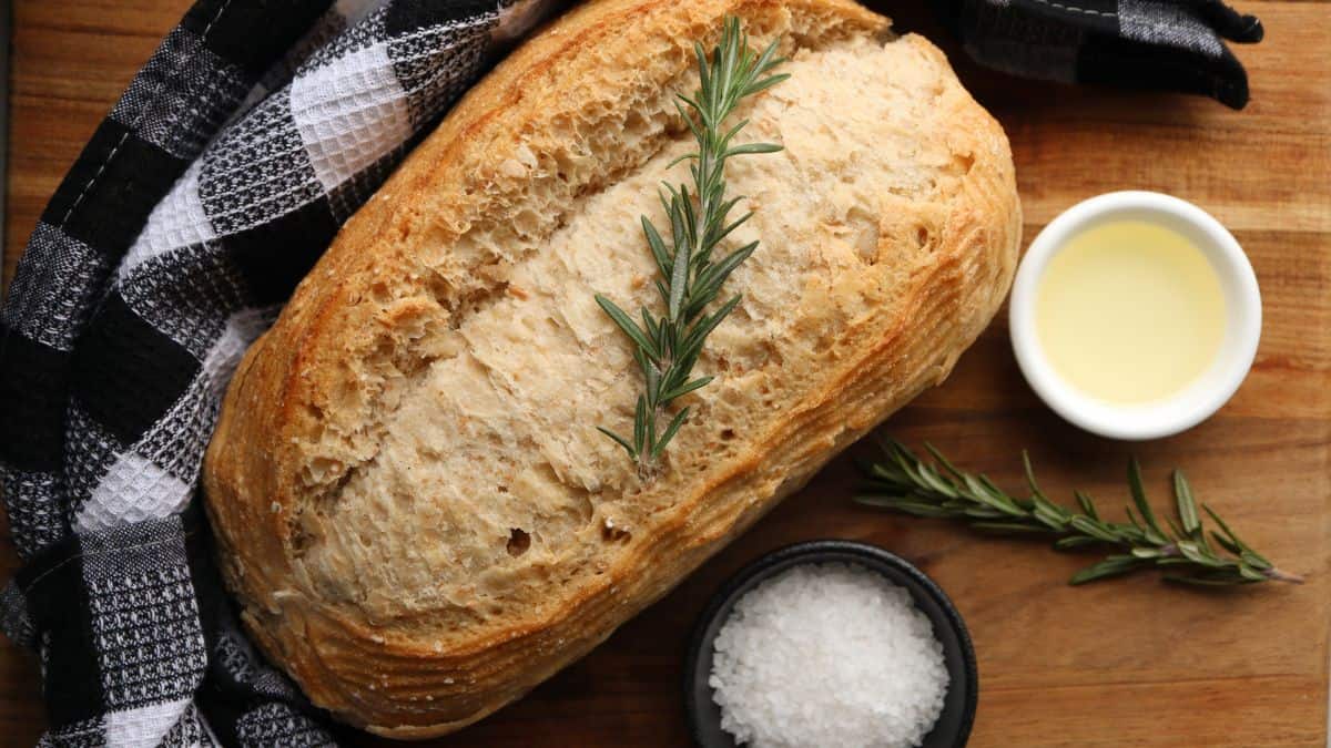 A loaf of herb bread on a wooden board.