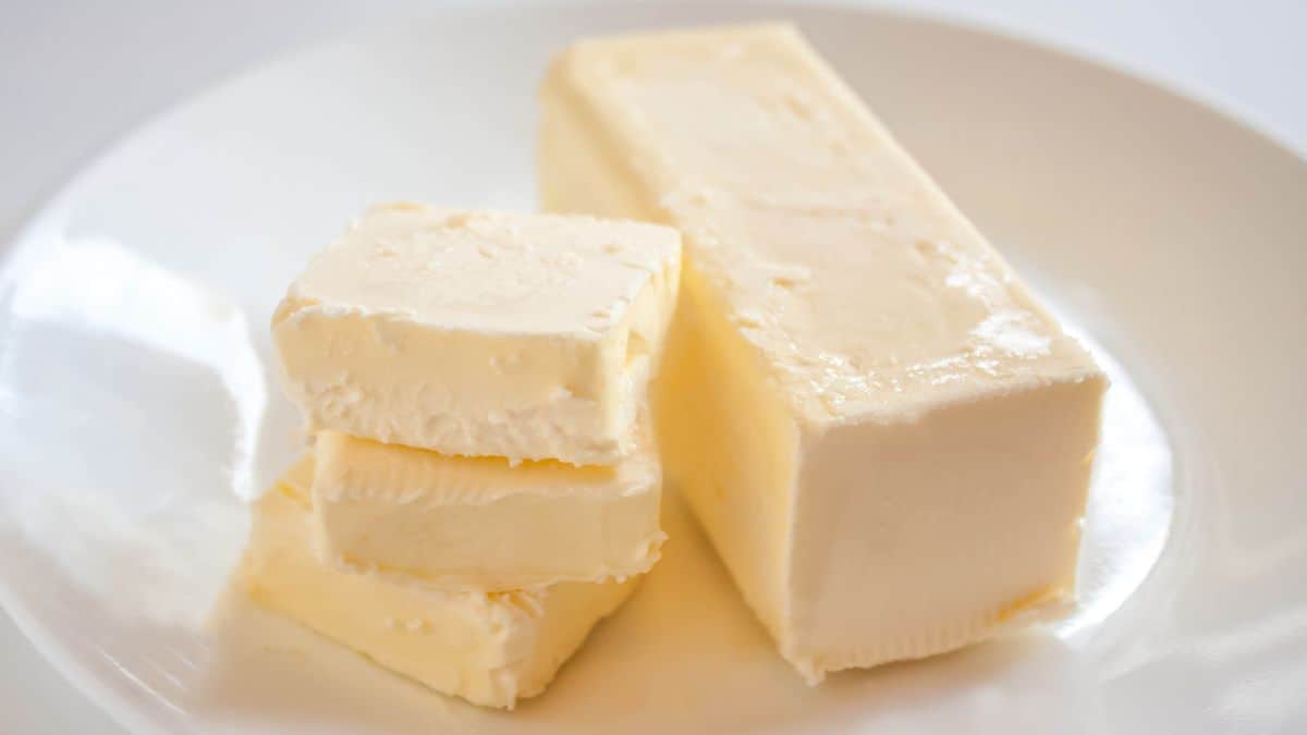 Stick of butter on a white plate.