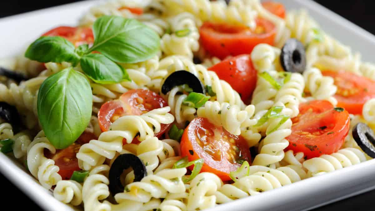 Fusilli pasta with sauce on a white plate.