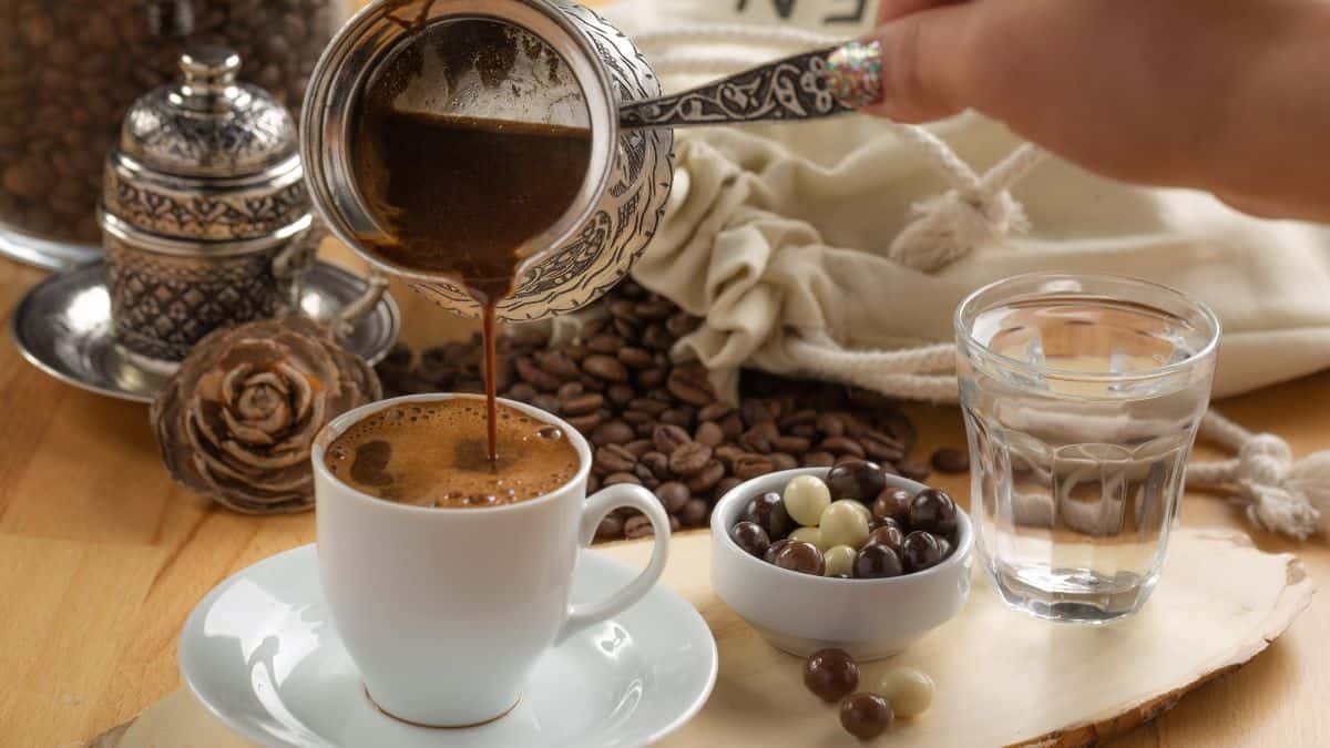 Person pouring Turkish coffee in a cup.