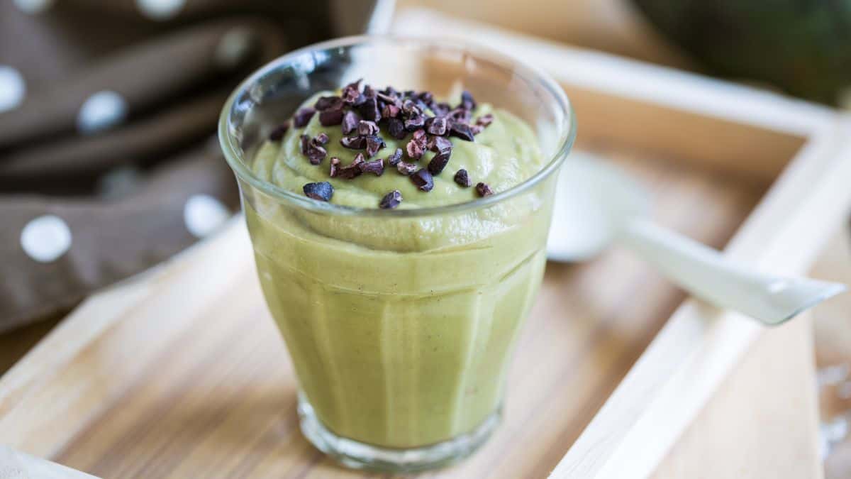 Green smoothie topped with cacao nibs.