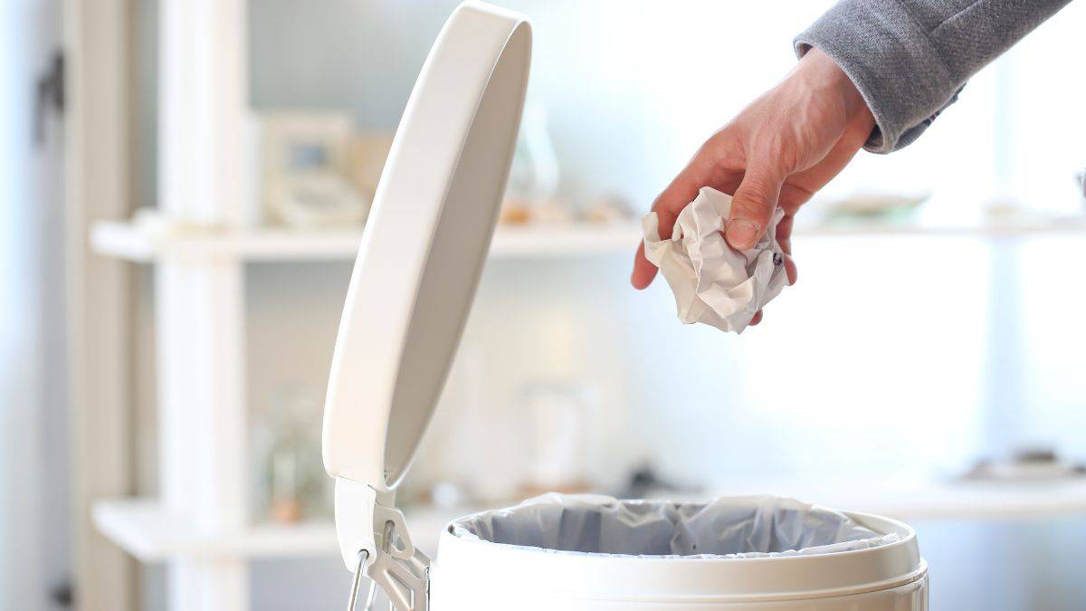 Man throwing in garbage can.