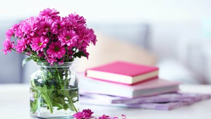 Flower vase with books in the background.