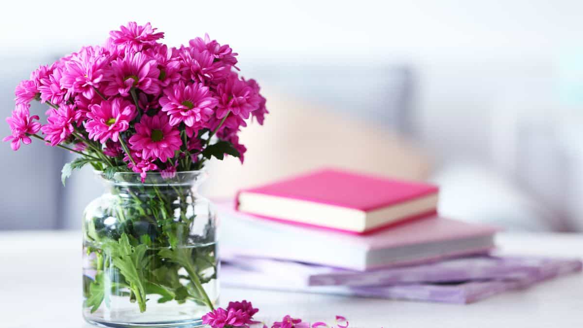 Flower vase with books in the background.