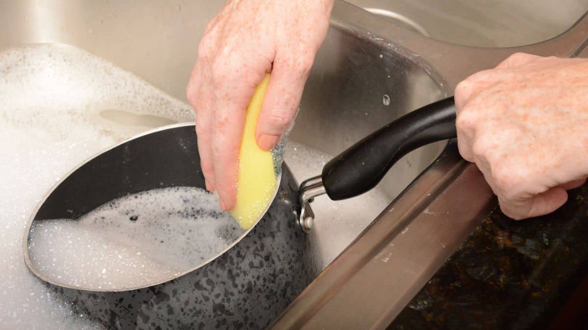 Pot being washed in a sink.