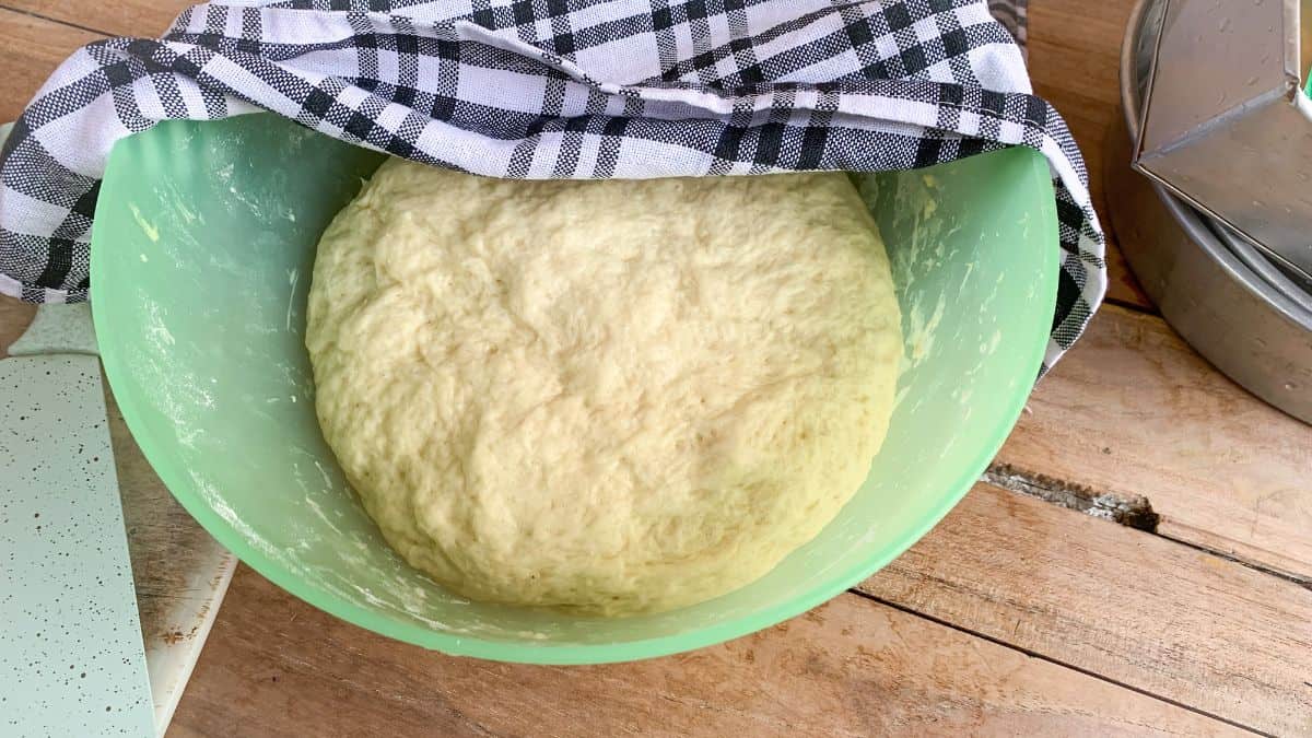 Dough being proofed covered with a kitchen twoel.