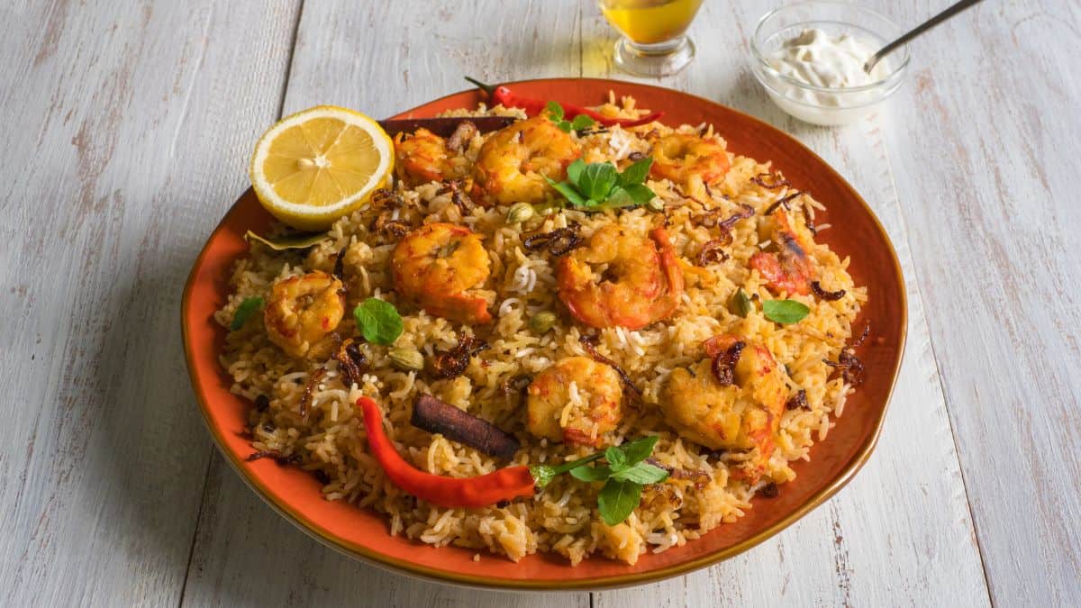 Memoni shrimp biryani on a brown plate.