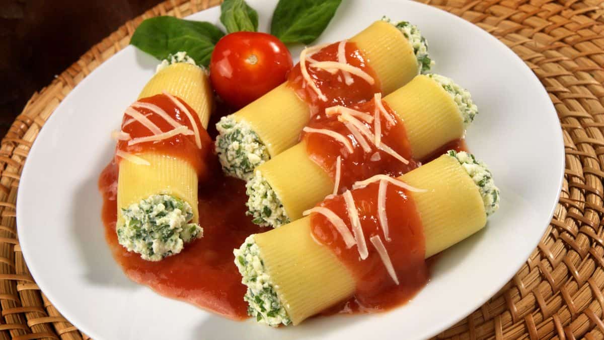 Stuffed cannelloni pasta on a white plate.