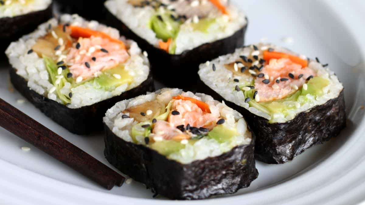 Four pieces of futomaki on a black plate.