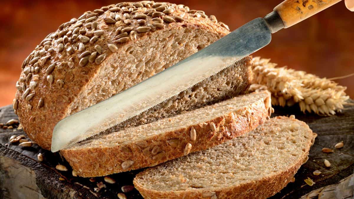 A loaf of bread being sliced.