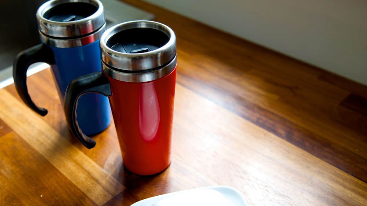 Two travel mugs on a table.