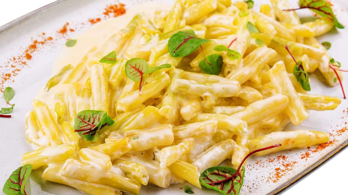 Gorgonzola pasta garnished with bsil leaves.