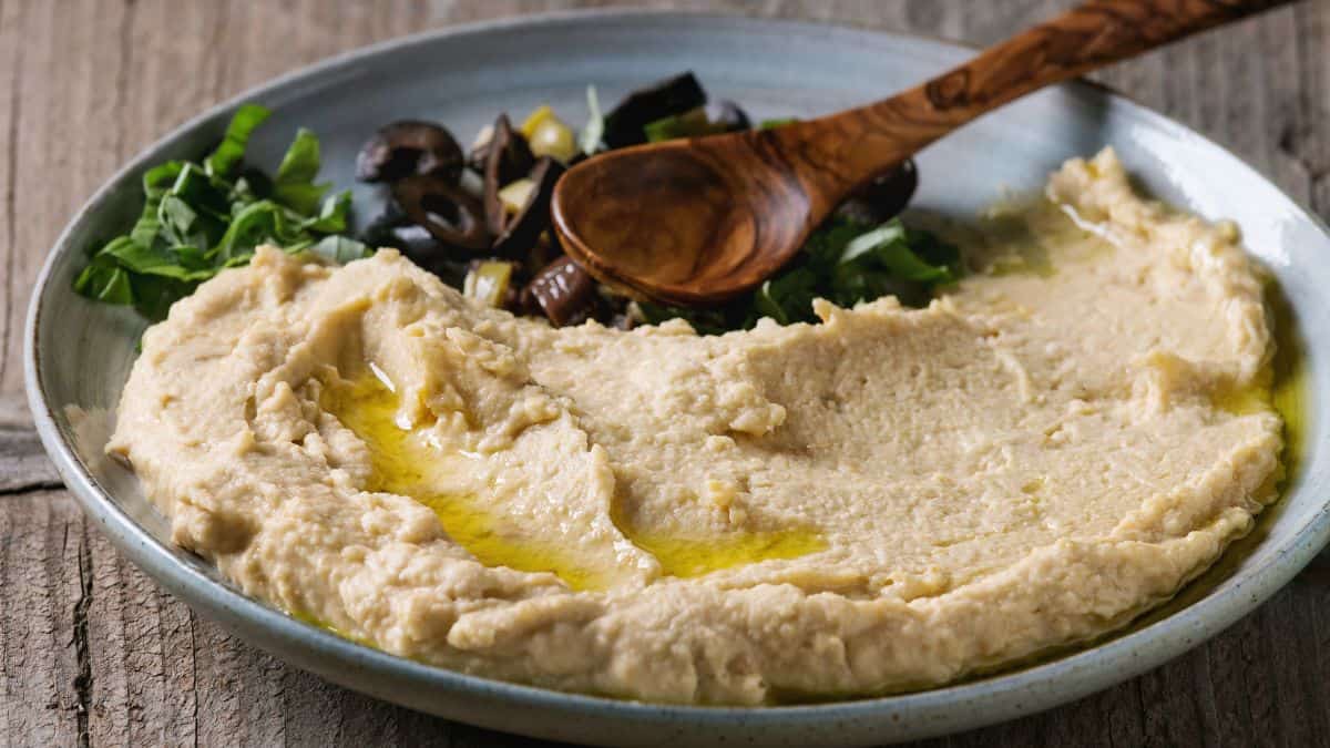 Olive and herb hummus in a wide bowl.