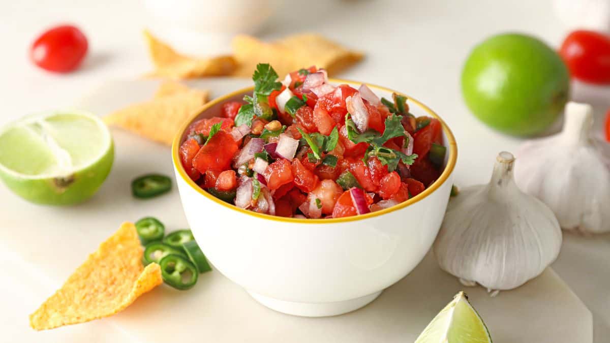 A bowl on pico de galo with doritos.