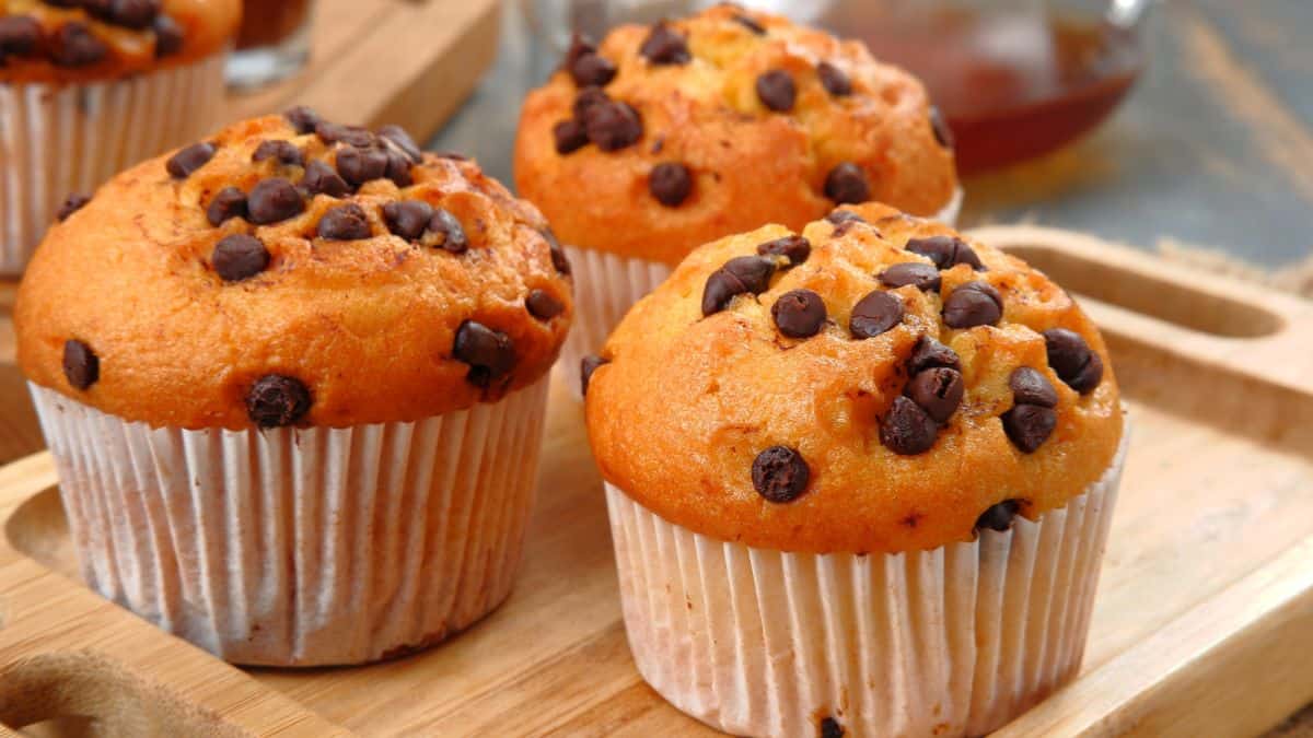 Three muffins pn a wooden board.