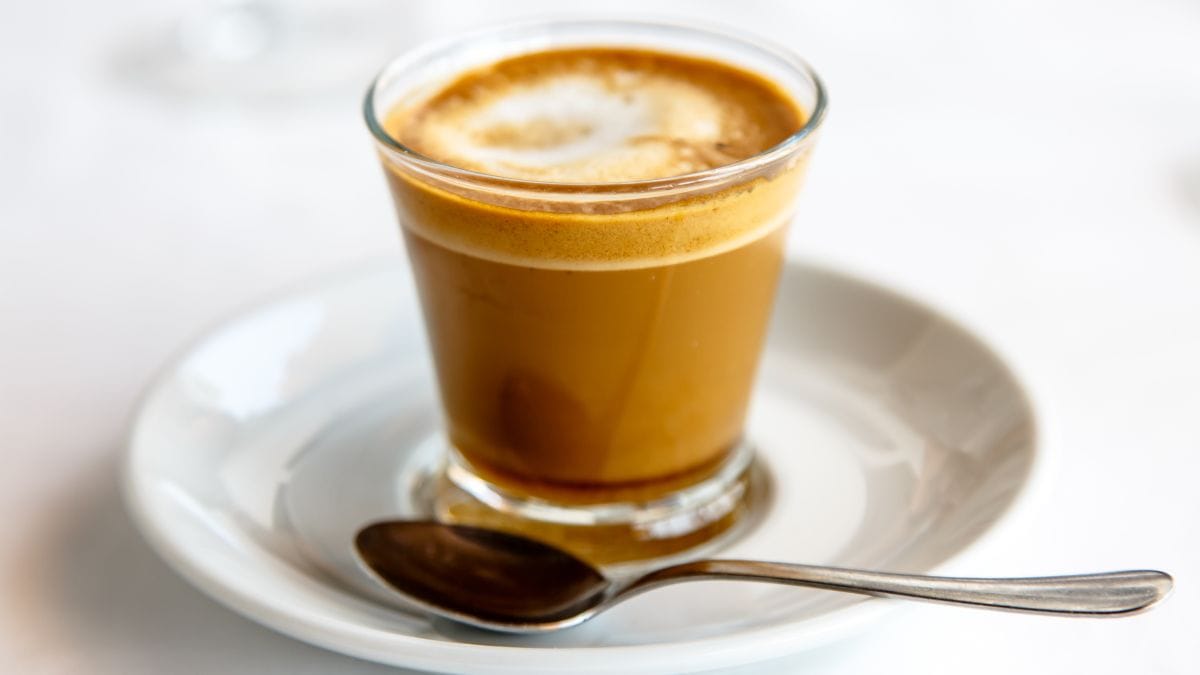 Cortado coffee in a glass cup.