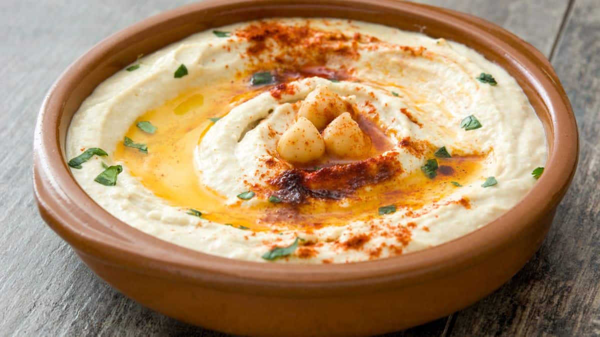 Classic hummus in a brown bowl.