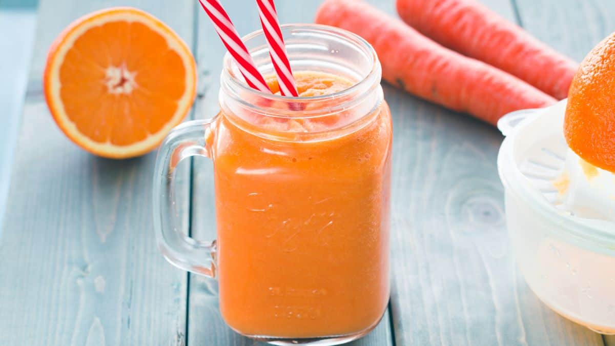 Carrot and orange smoothie in a jar.