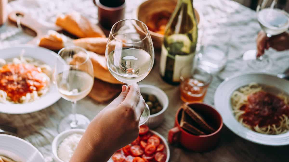 Persone with wine glass cheering.