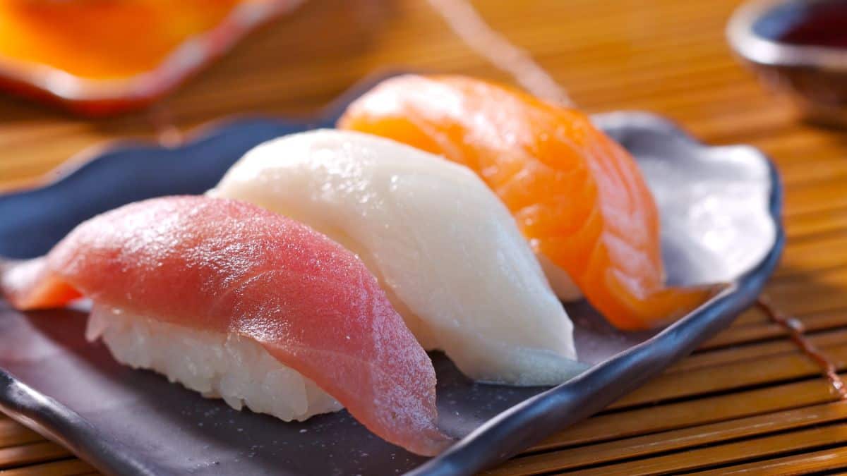 Nigiri on a black plate.