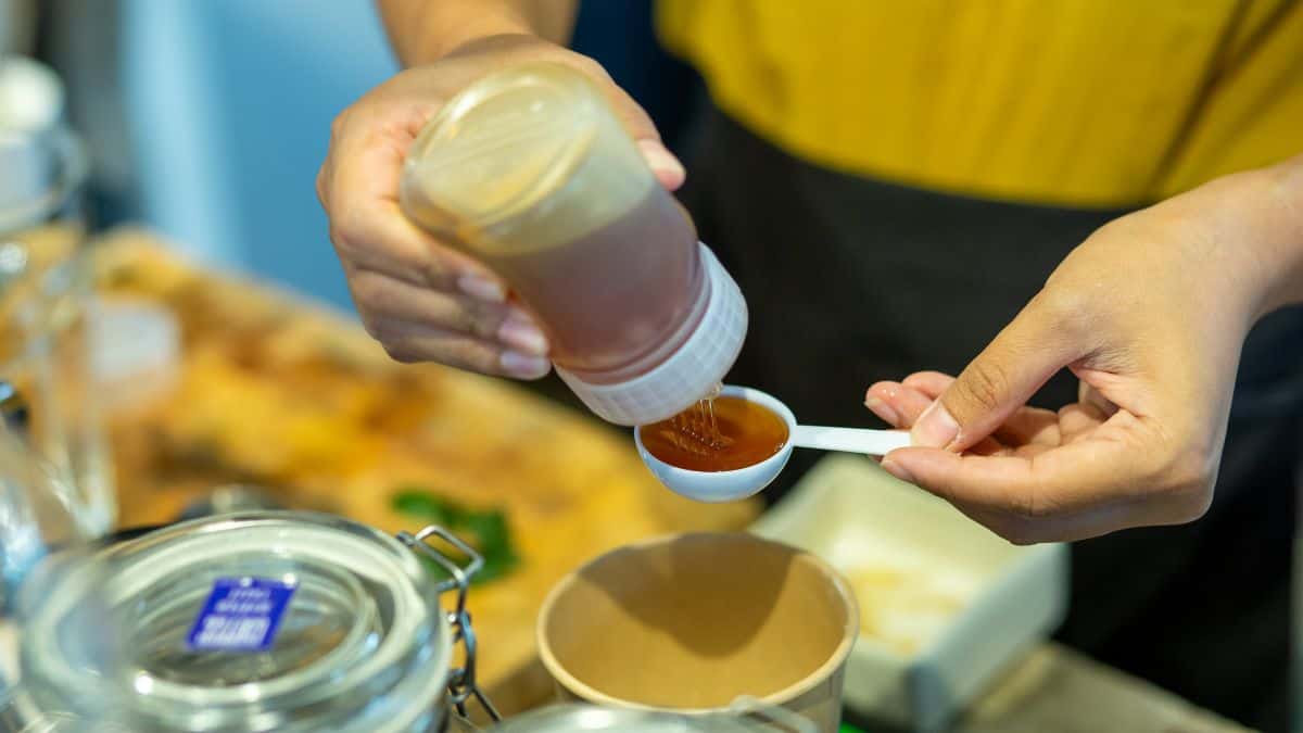 Person measuring honey.