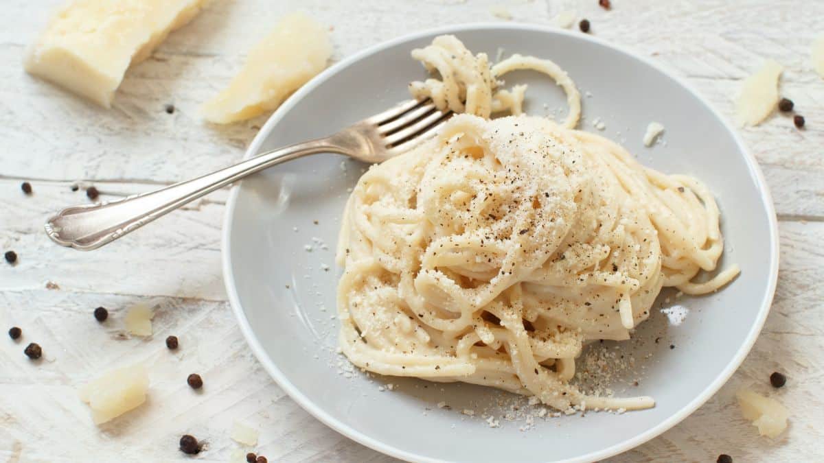 Cacio e pepe sauce with spaghetti on a white plate.