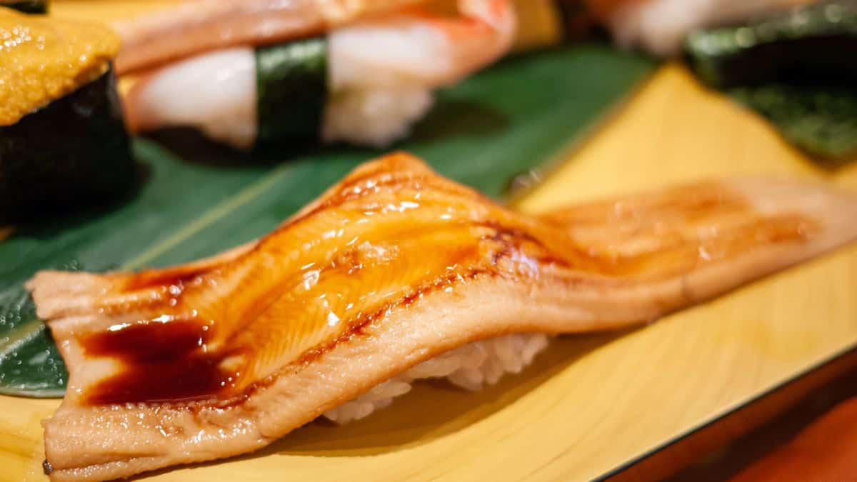 Anago nigiri on a wooden board.