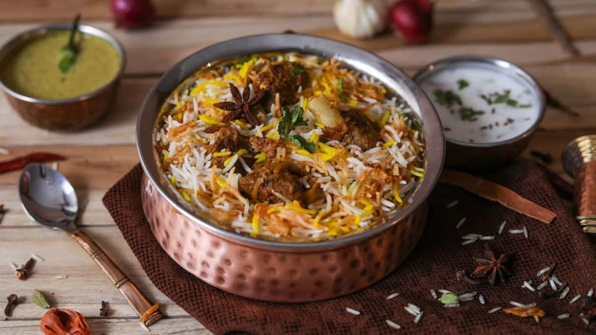 Chicken biryani in a copper bowl.