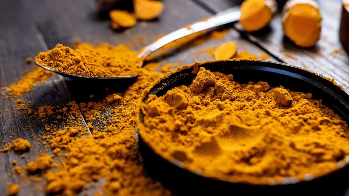 Turmeric powder in a bowl and spoon.