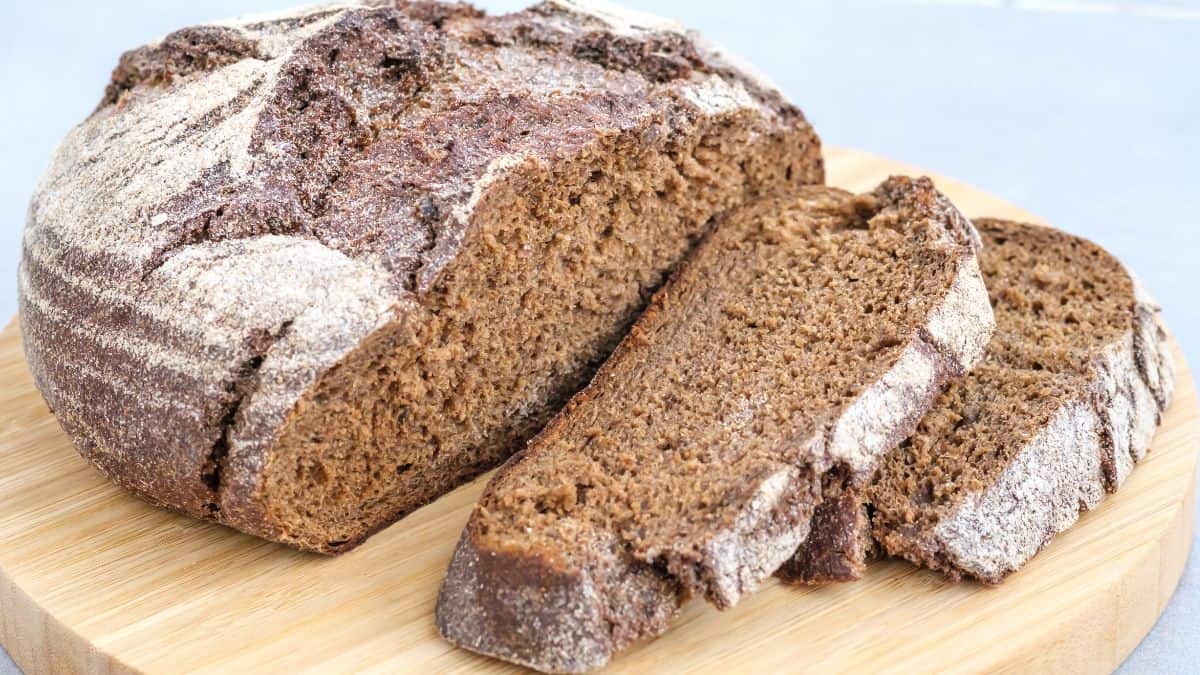 Sliced rye sourdough bread on a wooden board.