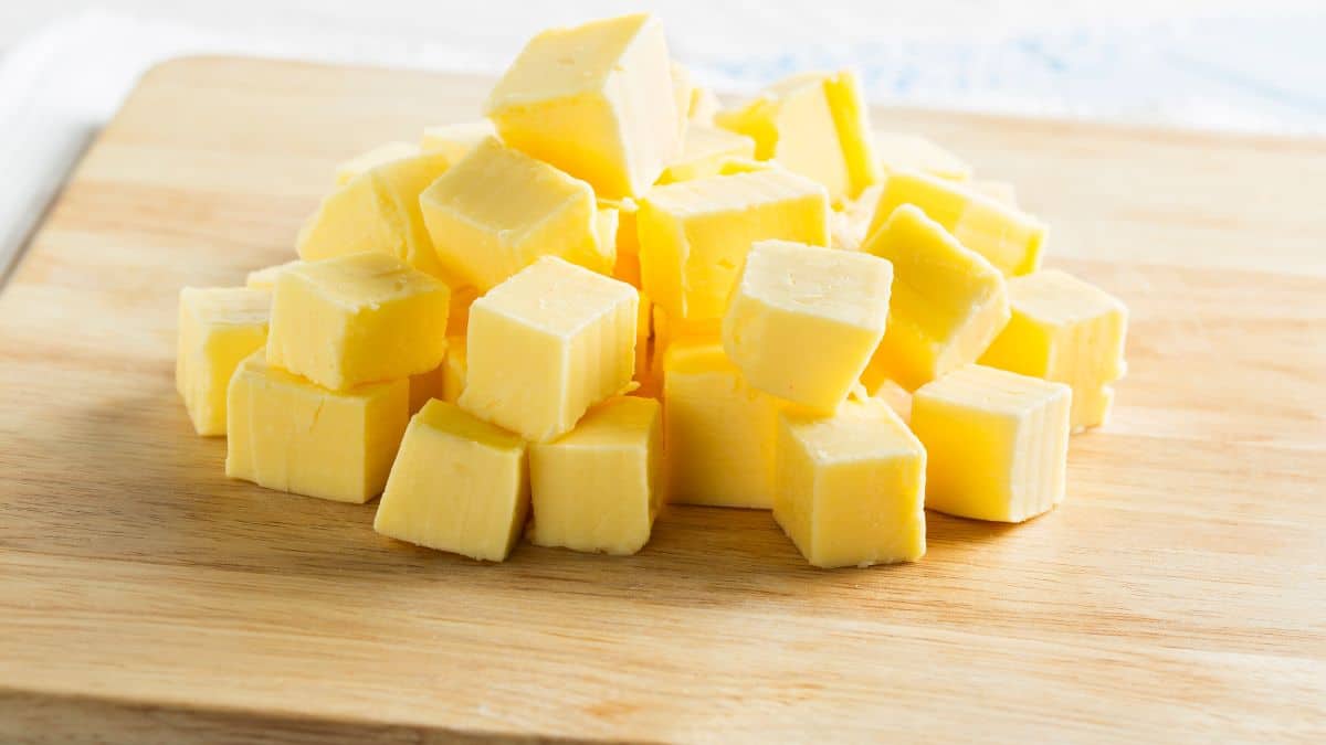 Small cubes of butter on a wooden board.