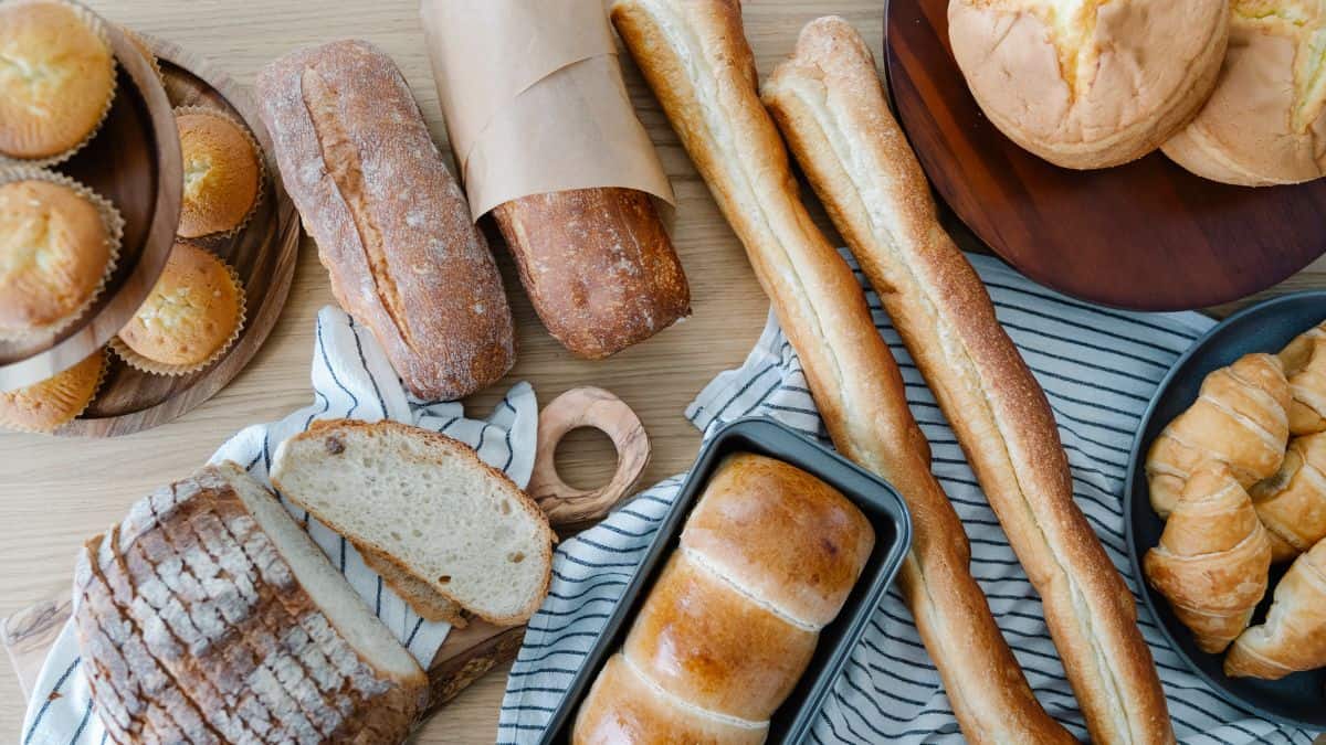 Various types of bread on a wooden board.