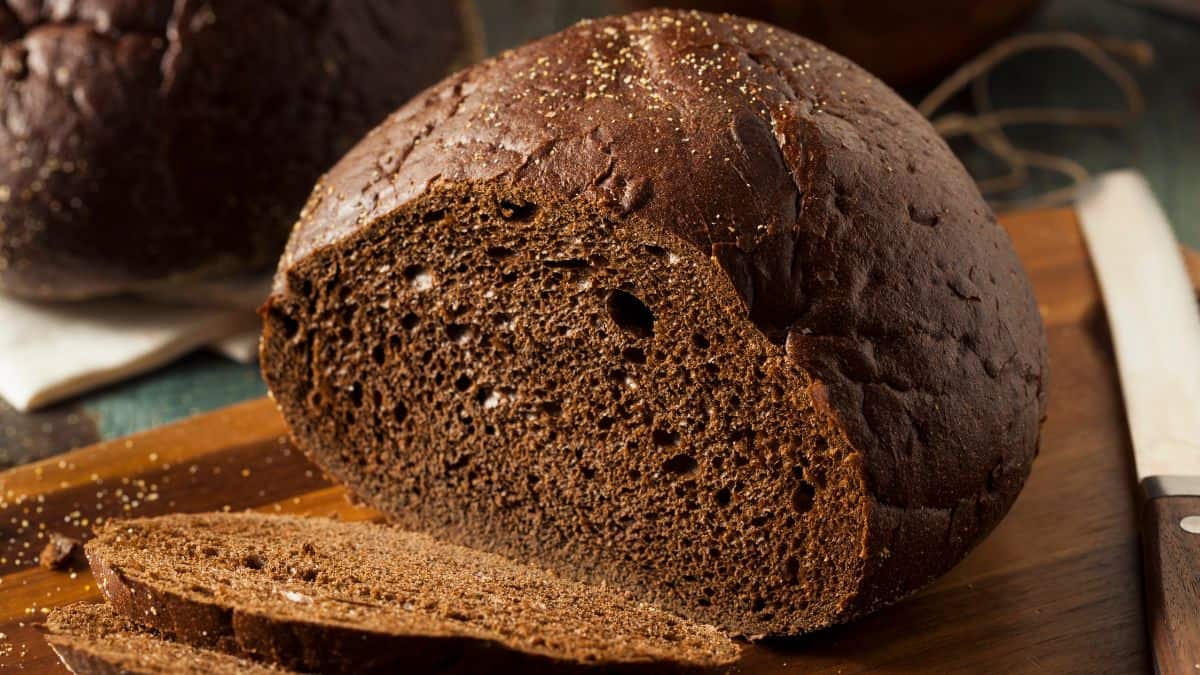 Loaf of pumpernickel on a wooden board.