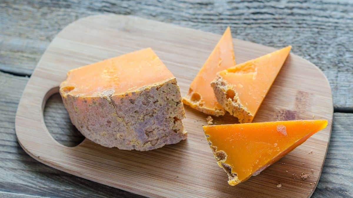 Blocks of mimolette chesse on a wooden board.