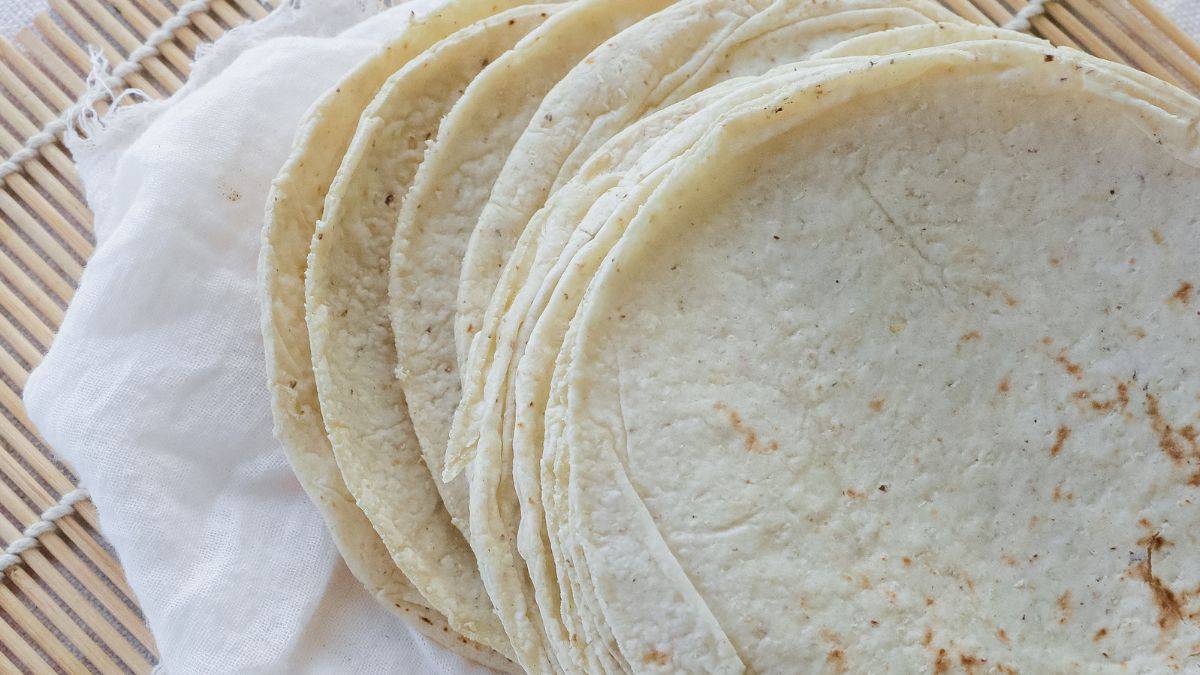 Tortillas stacked on a muslin cloth.