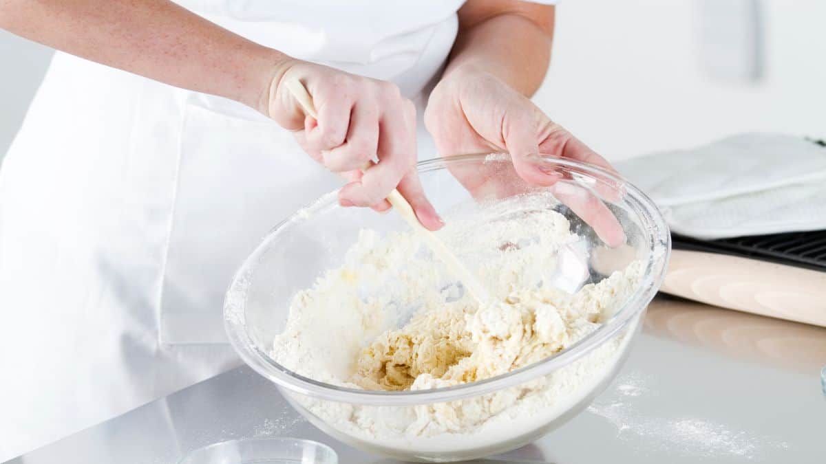 Mixing water and flour in a bowl.