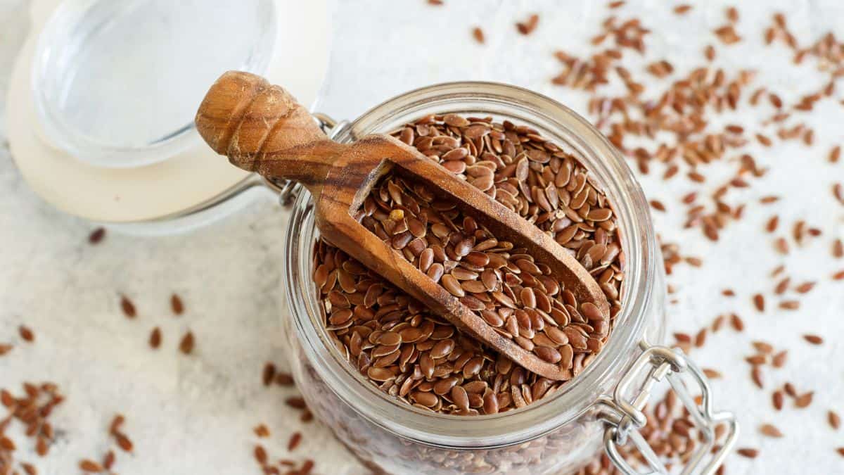 Flax seeds in a jar with wooden handle.