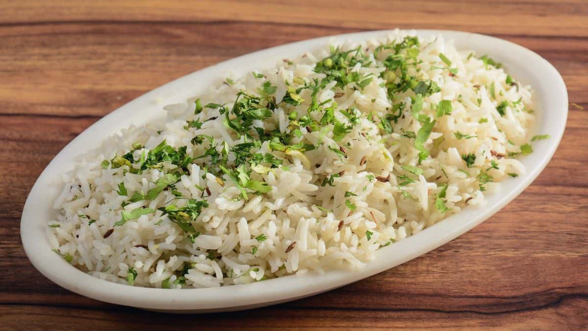 Cumin flavored rice on a white plate.