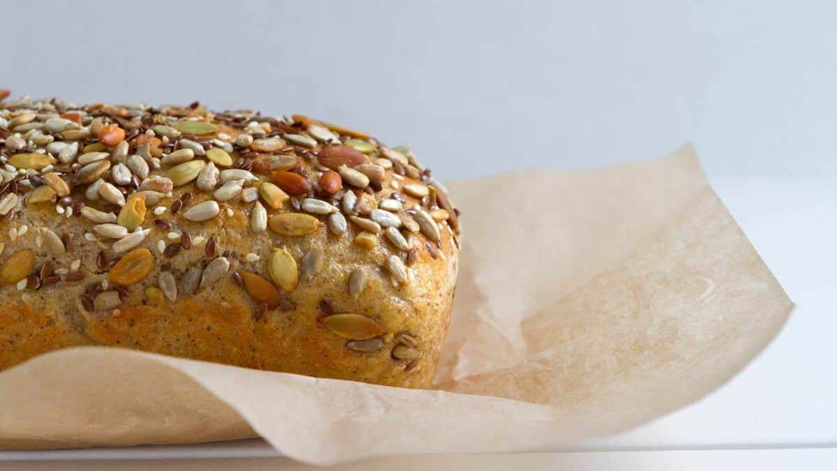 Loaf of seeded bread on a parchment paper.