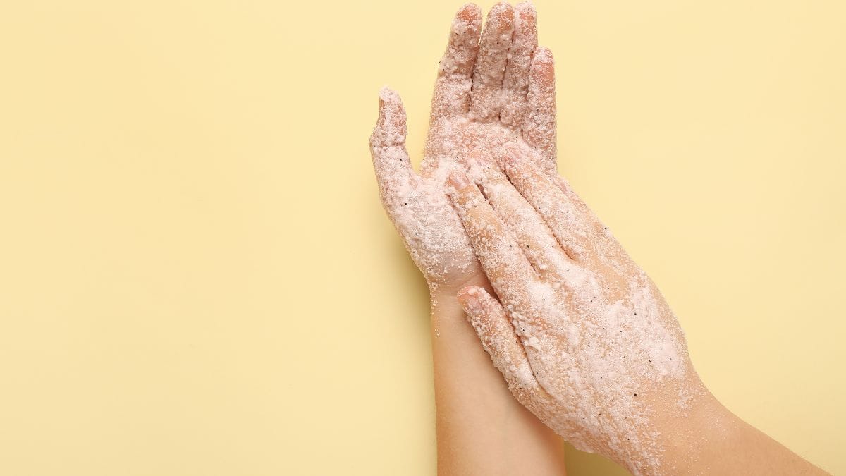 Woman exfoliating hands.