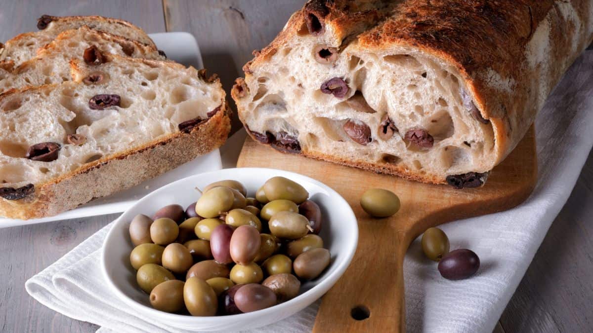 Sliced olive bread with olives in a small plate.